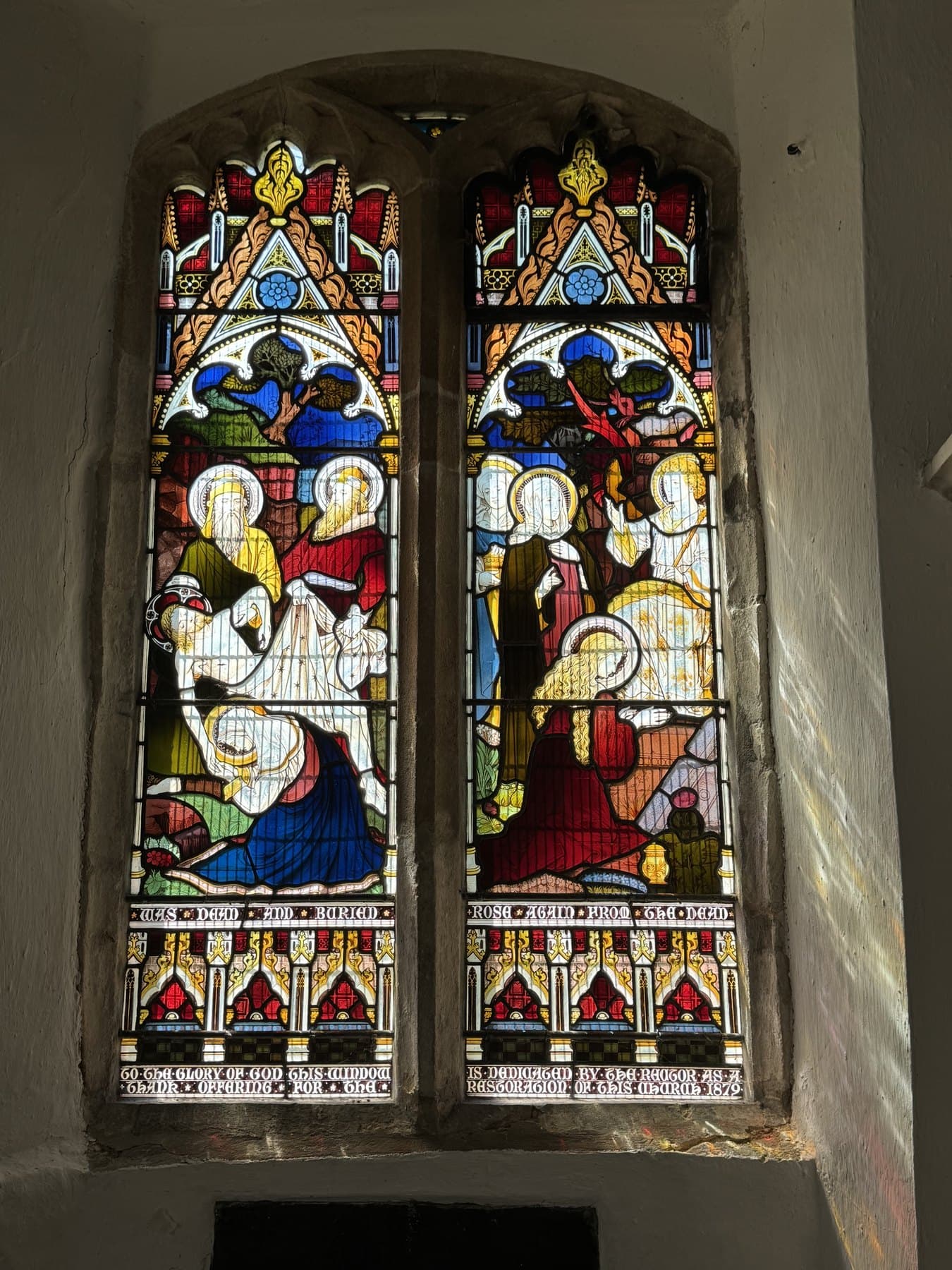 Vibrant stained-glass window panels inside All Saints Little Bradley.